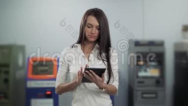 女商人在ATM背景下使用数字平板电脑，银行工作，女商人取款
